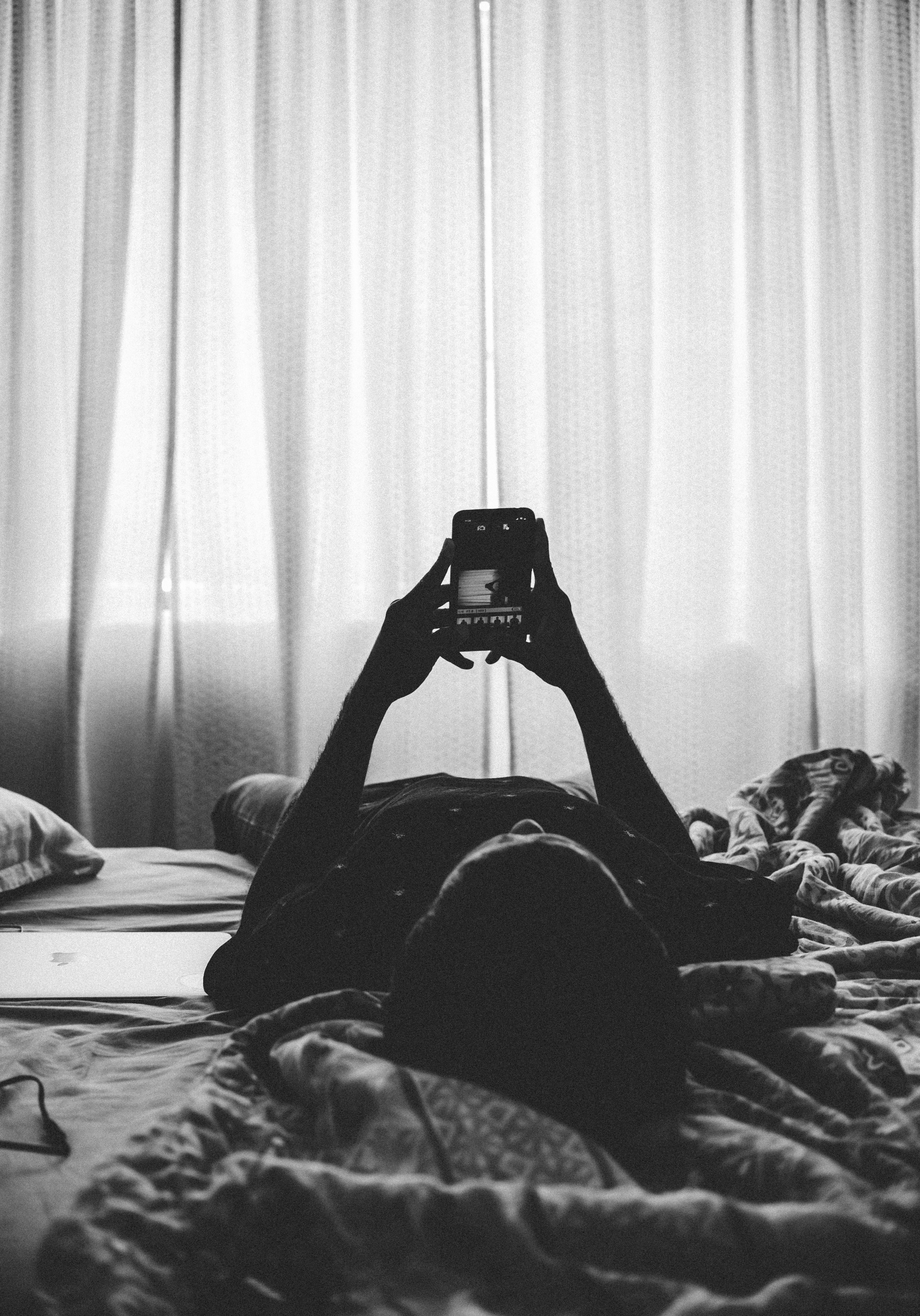 Person in bed checking a phone